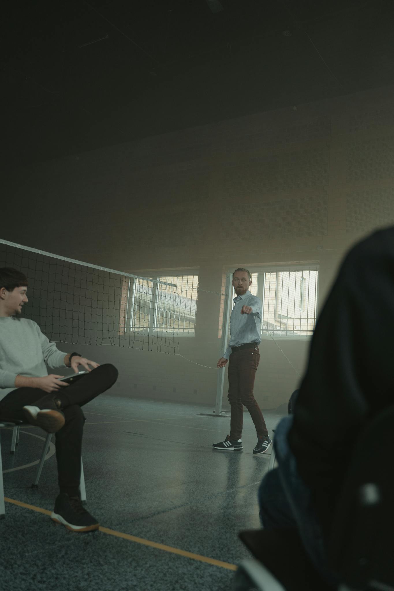 A supportive group session with a mentor guiding participants in a spacious indoor setting.