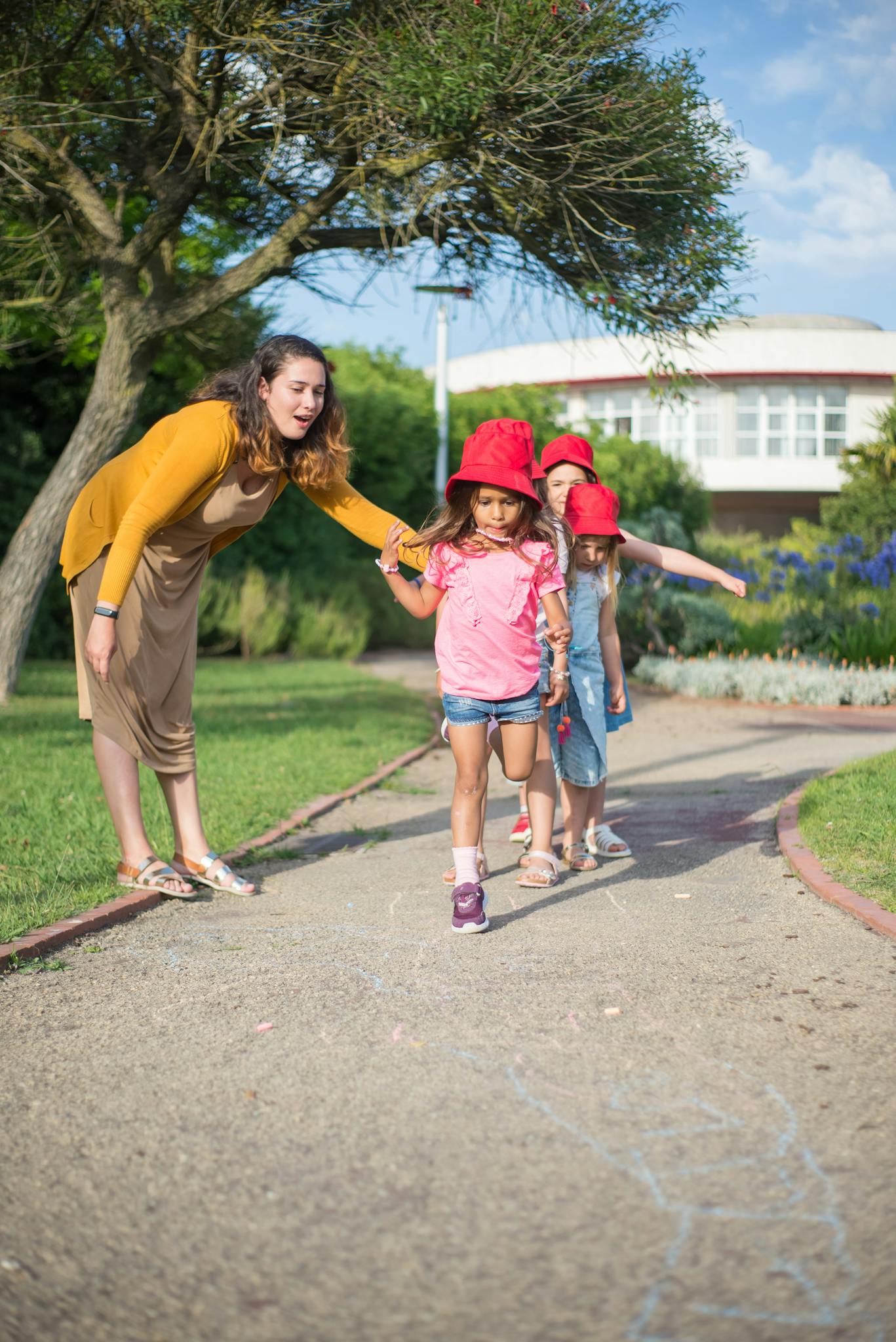 A woman walks with two children on a park path in Portugal.